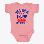 Yes I am A Trump Baby Onesie Art featuring a pink onesie with bold text saying 'YES I'M A TRUMP Baby GET OVER IT'