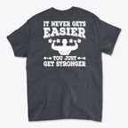 Back Print Never Gets Easier Fit graphic tee showcasing a motivational strength message on a dark gray shirt.