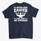 Back Print Never Gets Easier Fit graphic t-shirt featuring motivational text about strength training.