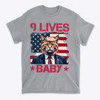 Nine Lives Baby Red Letters Art graphic tee featuring a cat in a suit against an American flag background.