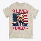 Nine Lives Baby Red Letters Art graphic tee featuring a cat in a suit with an American flag background.