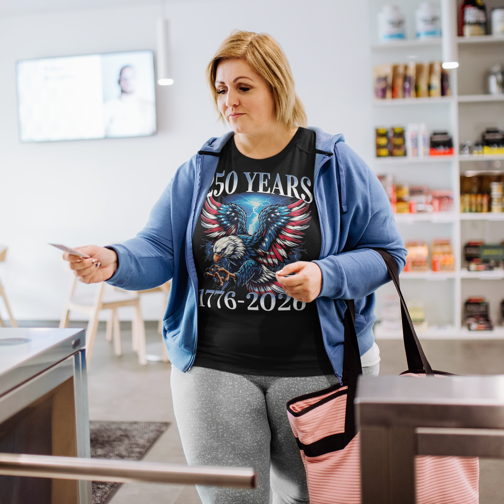 Person wearing a 250 Years 1776 2026 Graphic Tee while making a purchase in a cafe.