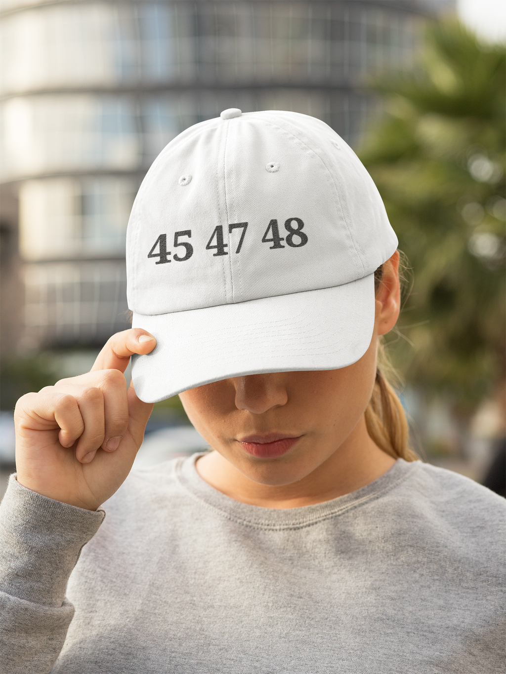 A woman wearing the 45 47 48 Trump Edition Headwear in outdoor setting, showcasing a strong sense of individual values.