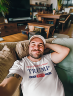 Person wearing Support Trump Keep America 2028 graphic t-shirt while relaxing at home.