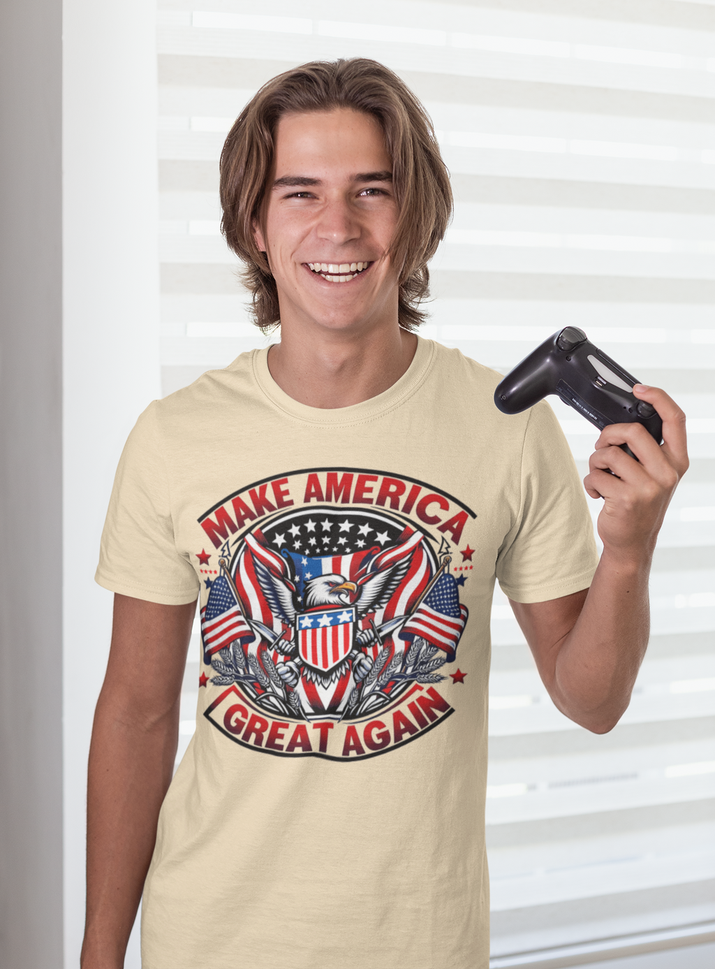 Smiling young man wearing a t-shirt with Make America Great Again On Eagle design, holding a game controller.