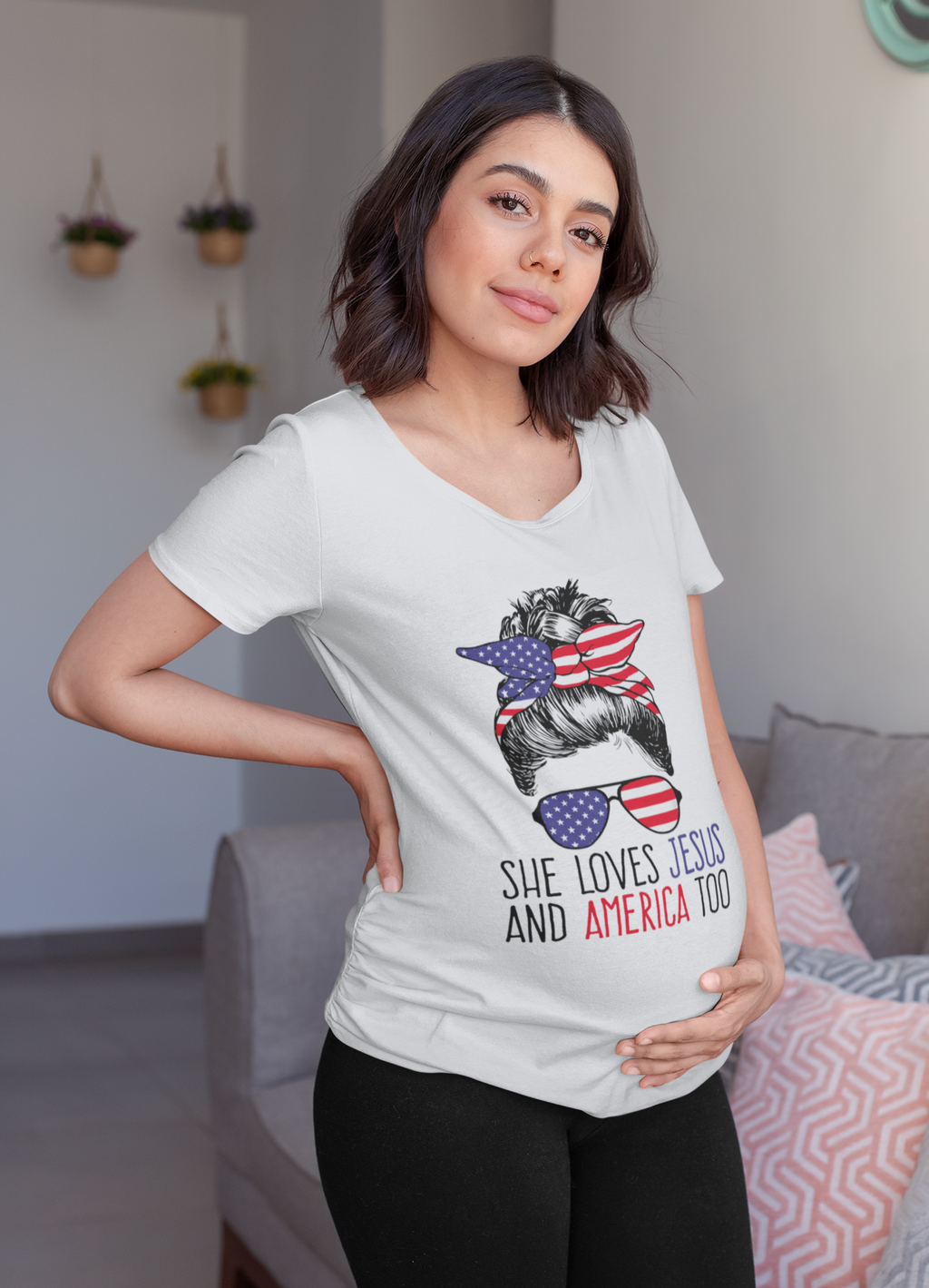 Woman wearing a t-shirt with the phrase 'She Loves Jesus And America Too' and patriotic designs.
