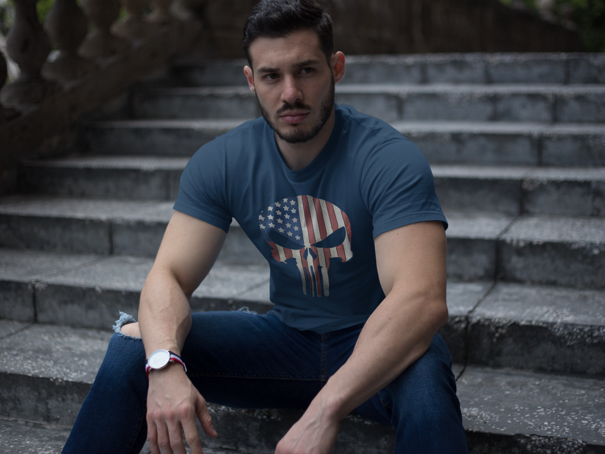 Man sitting on stairs wearing Punisher in Stars And Stripes 2 t-shirt, showcasing conservative American pride.
