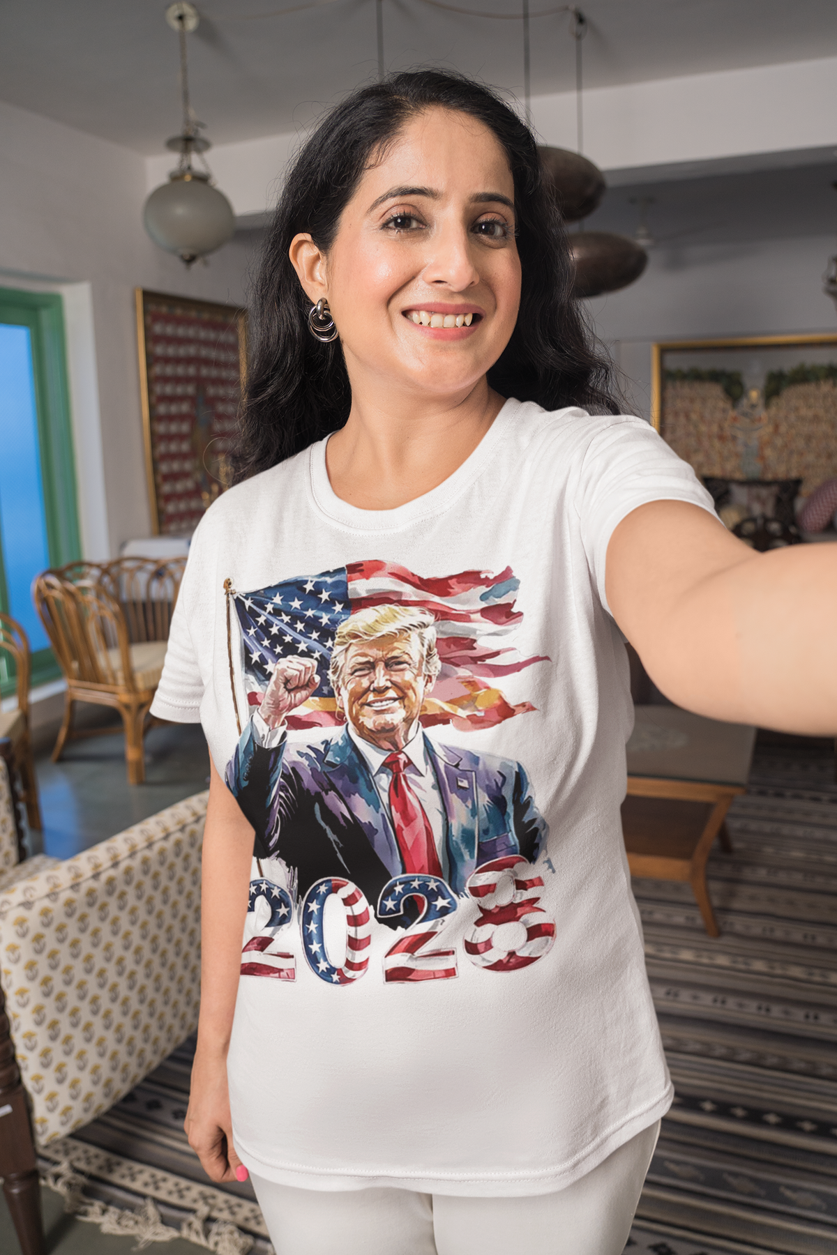 Trump 2028 Raised Fist Print Tee - Woman wearing graphic t-shirt featuring Trump and American flag.