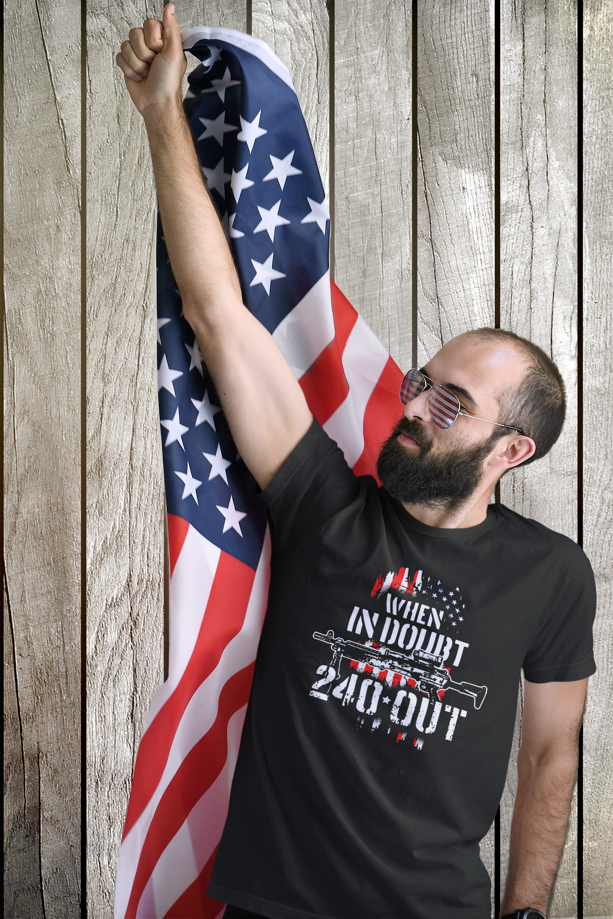 Patriotic man wearing When In Doubt 240 Out Graphic Twill Cap t-shirt with USA flag background.