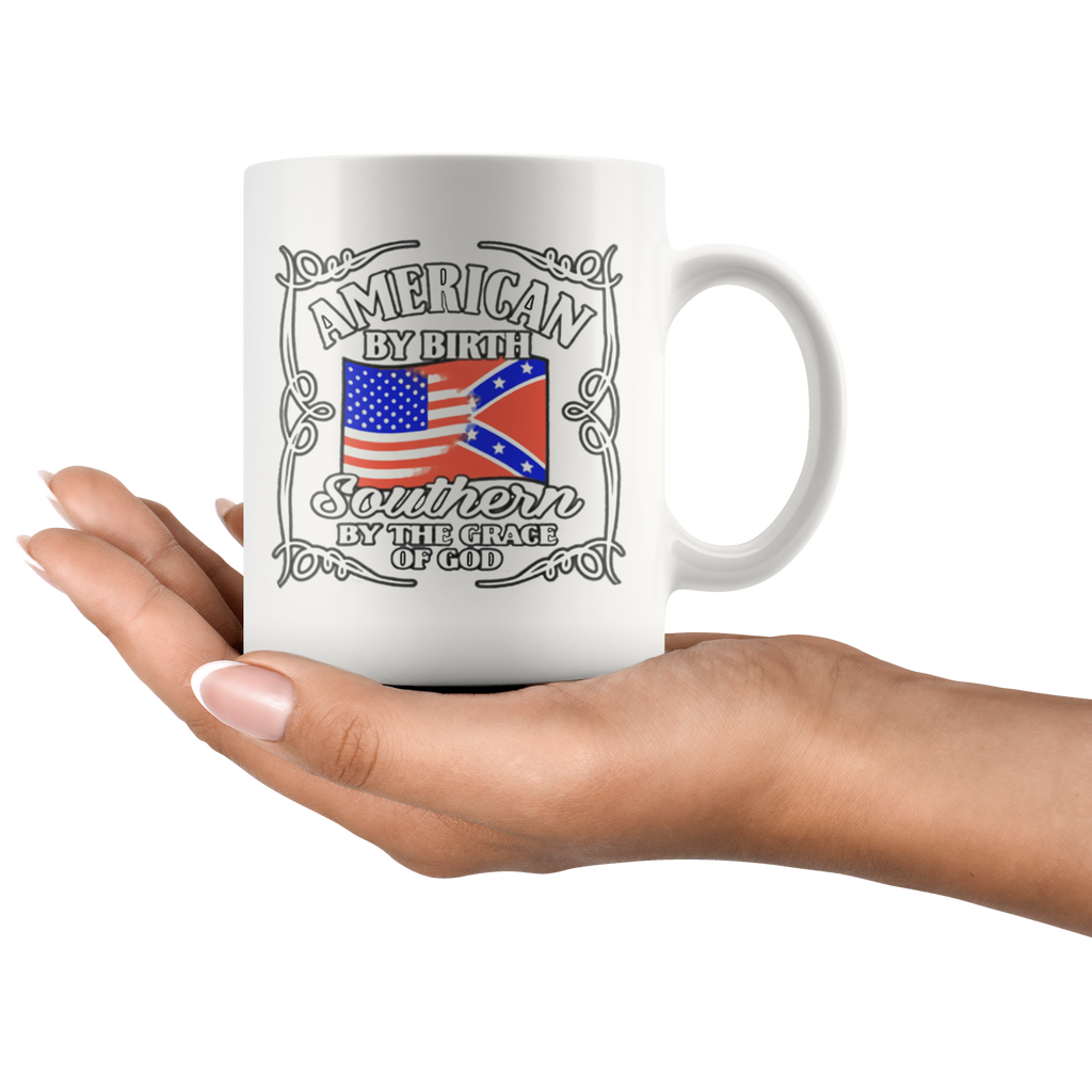 "American By Birth Southern By The Grace Of God Wht" mug with patriotic and Southern heritage design held in hand.