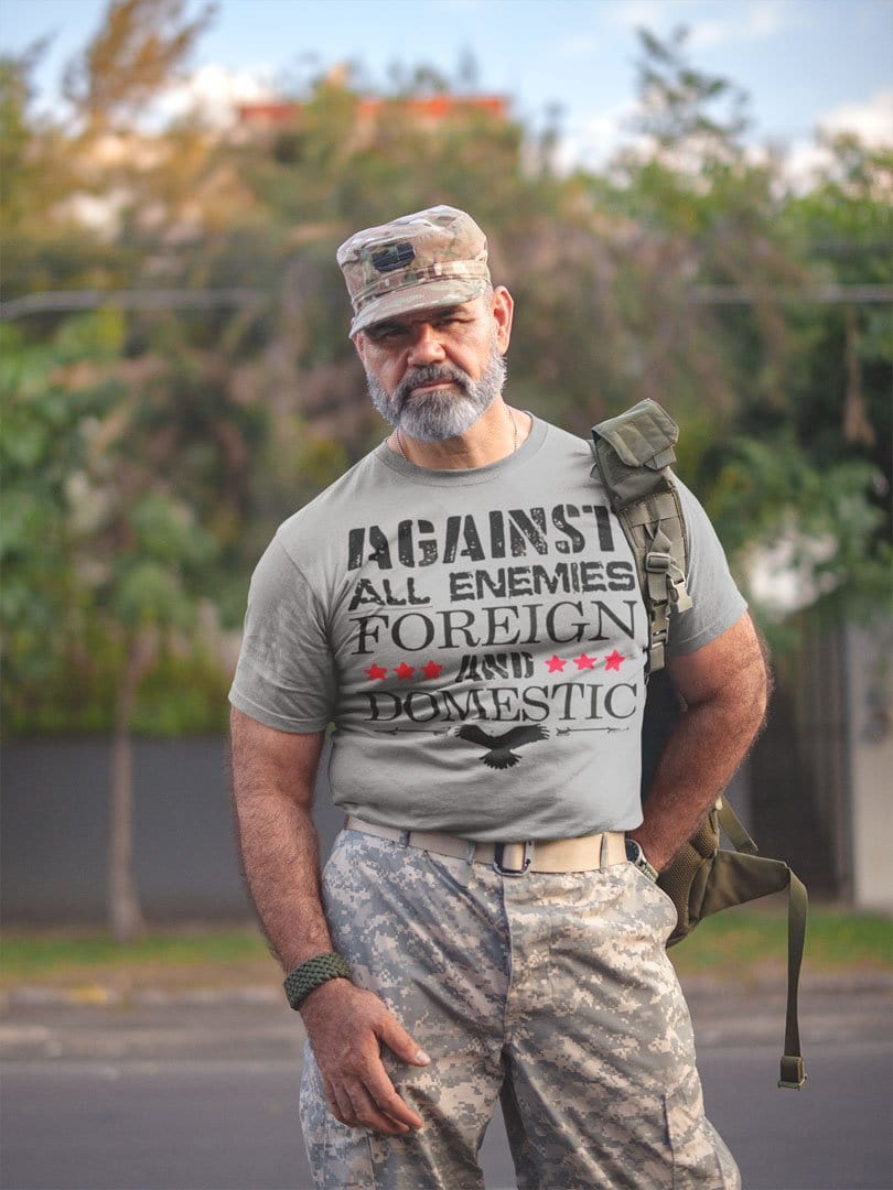 Man wearing 'Against All Enemies Foreign And Domestic' tee, camo pants