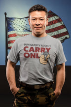 Gun Safety Rule Always Carry One t-shirt with graphic design and American flag backdrop.