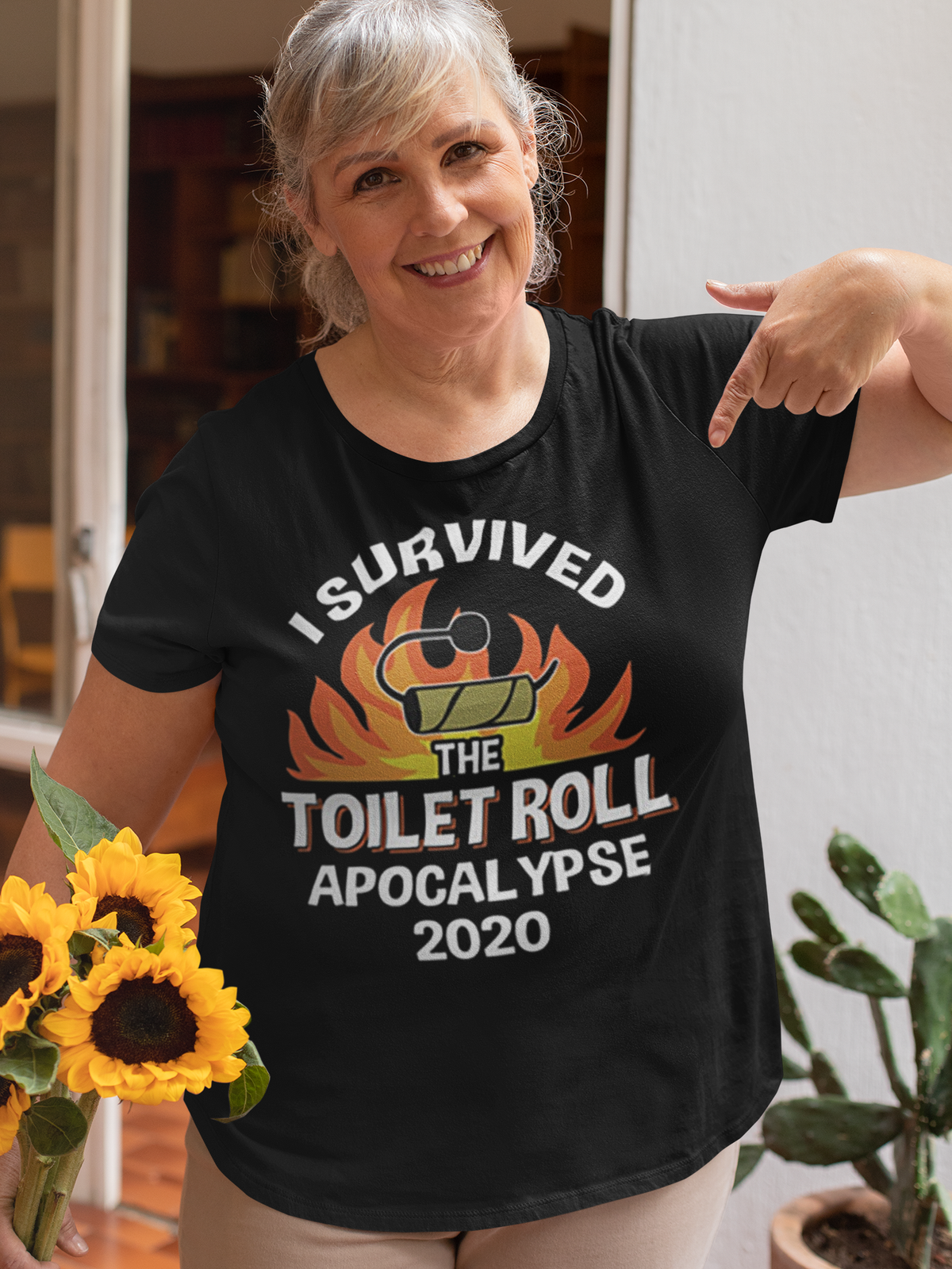 Woman wearing 'I Survived The Toilet Roll Apocalypse 2020' shirt holding sunflowers