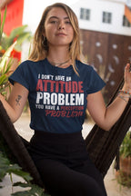 Woman wearing 'Attitude Problem Funny Graphic Tee' with bold typography sitting on a swing outdoors.