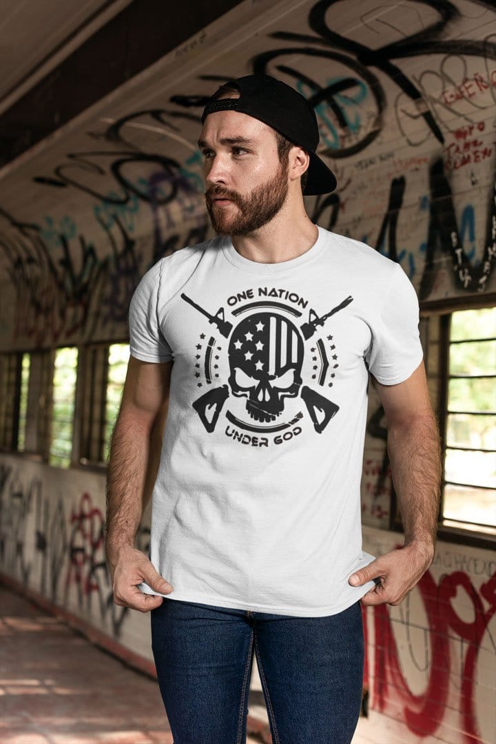 Man wearing God And Country Skull Rifles USA t-shirt in graffiti-covered hallway