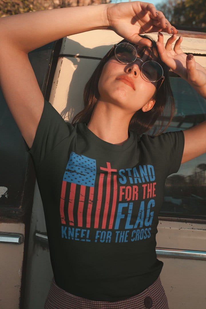 Woman wearing Stand For The Flag Kneel For The Cross t-shirt expressing personal values and patriotism.
