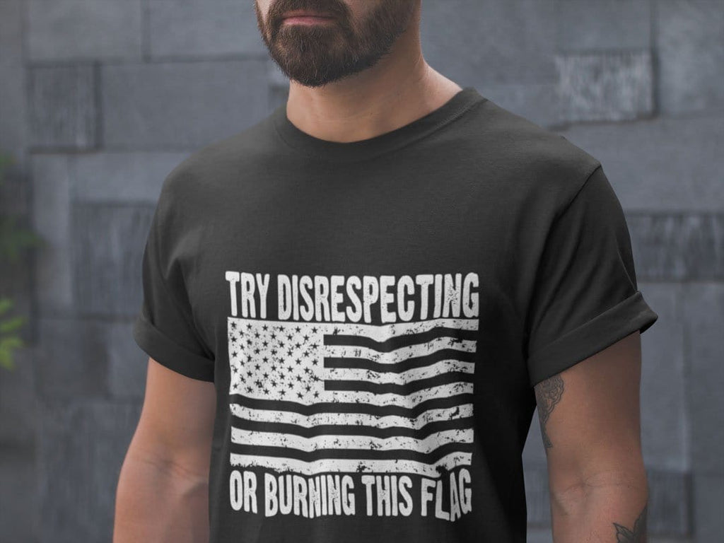 Man wearing "Try Disrespecting Or Burning This Flag" graphic t-shirt, showcasing patriotic apparel in black.