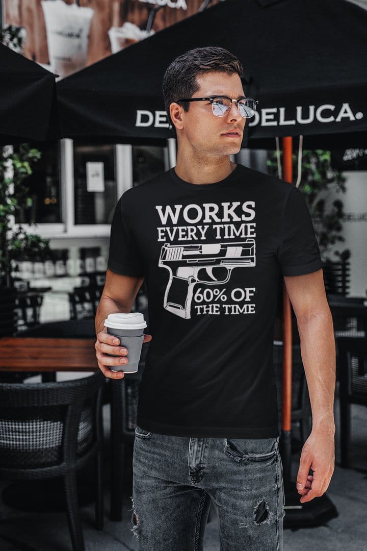 Man wearing 'Sixty Percent Of The Time It Works' graphic t-shirt holding coffee cup.
