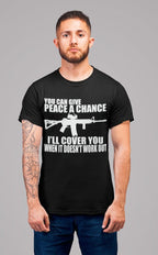 Man wearing 'Peace Fails My Ar15 Has Your Back' graphic t-shirt standing against gray background