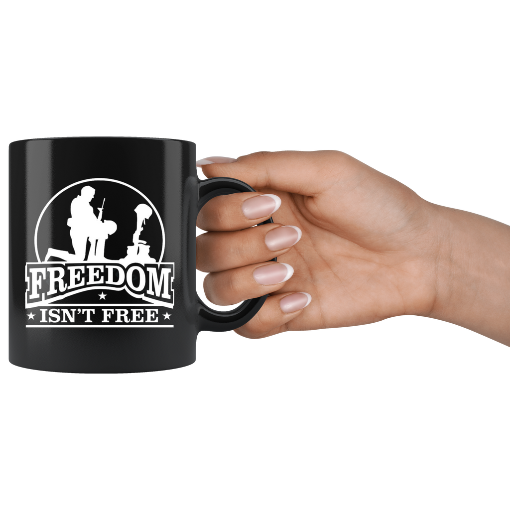 Hand holding black mug with Freedom Isn't Free Patriotic Graphic Tee design featuring a soldier and cross.
